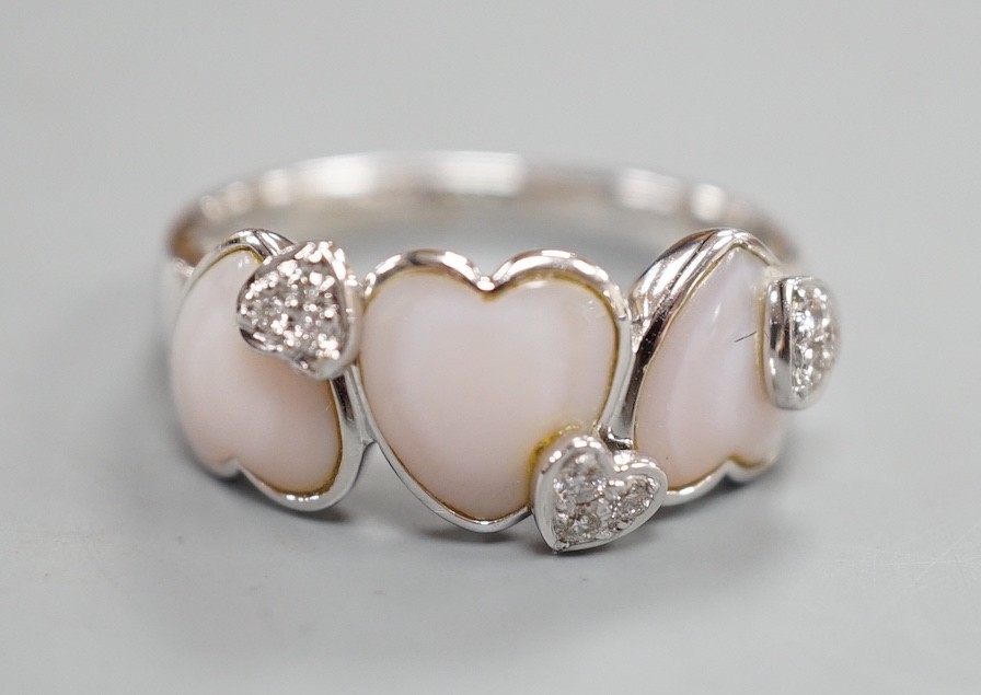A modern 750 white metal three stone heart shaped mother of pearl? and diamond chip cluster set half hoop ring, signed Damas, size Q, gross weight 5.4 grams.